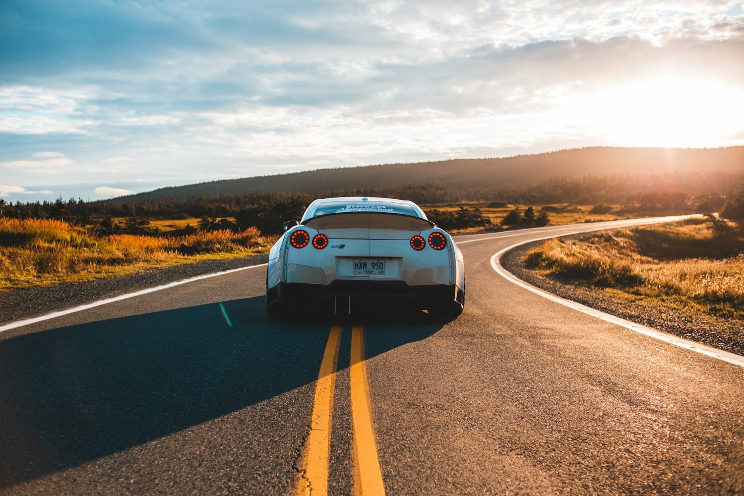 A car on an open road at sunset
